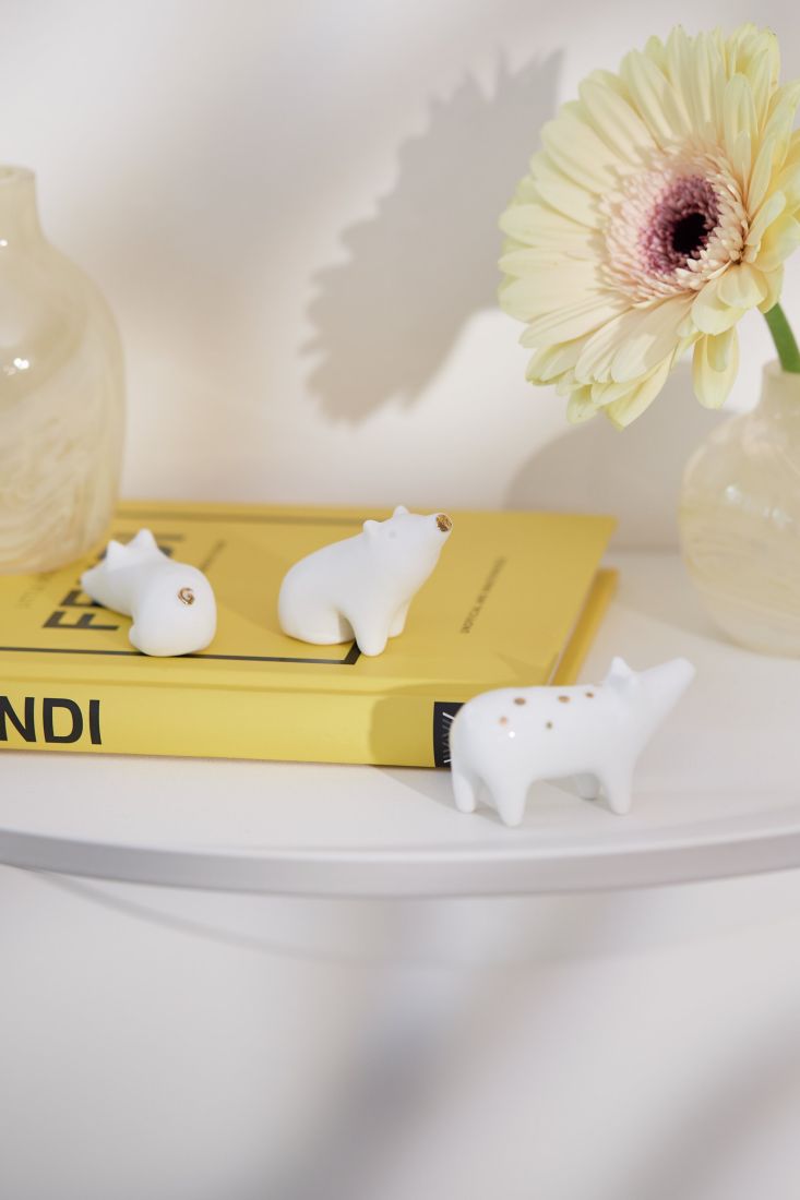 Drei kleine Porzellan Schweine als Glücksbringer Dekoration auf einem Schreibtisch