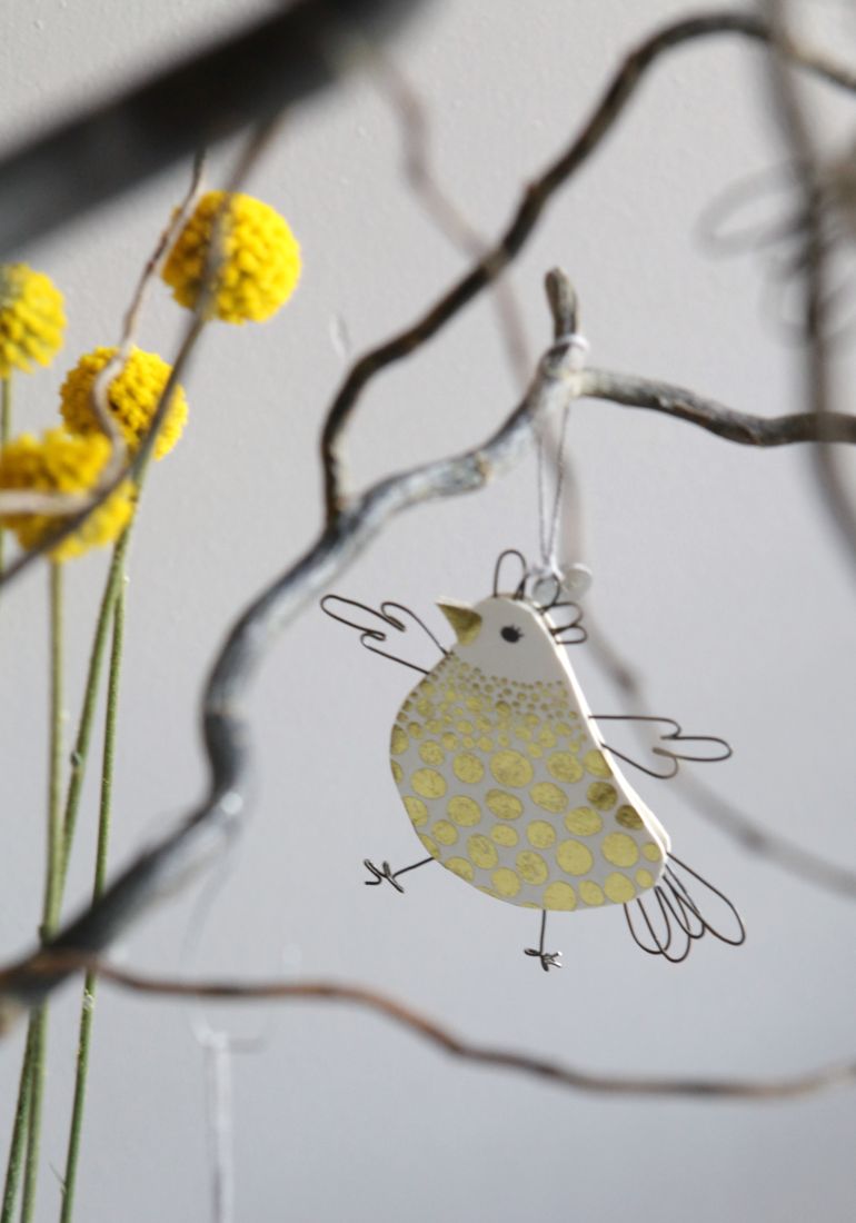 Modernes Draht-Küken als Dekoration an einem Frühlingszweig von Good old friends