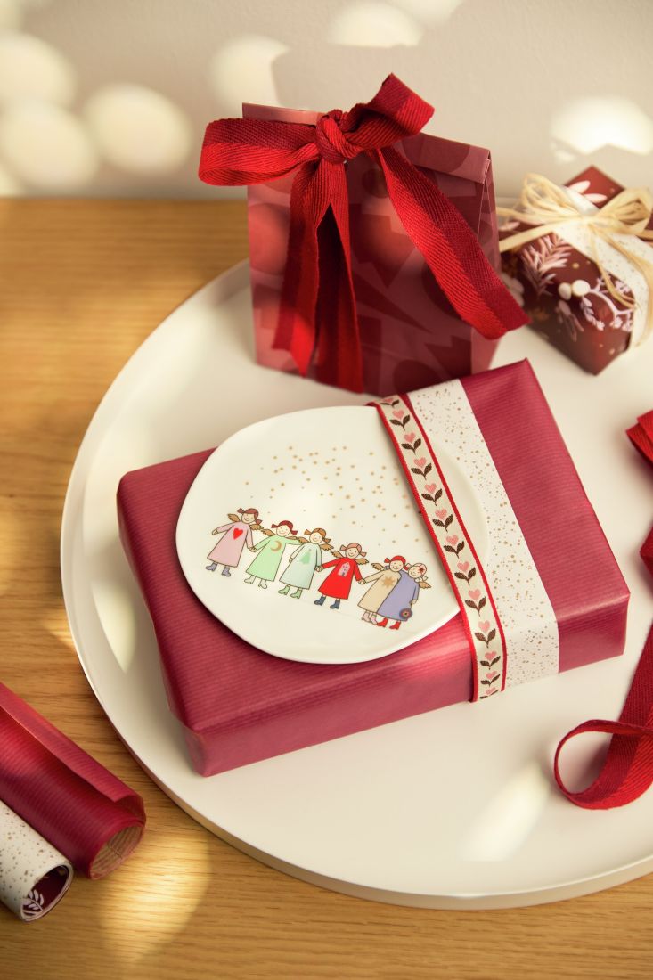 Der kleine räder Himmlische Schwestern Teller dekoriert auf einem Geschenk