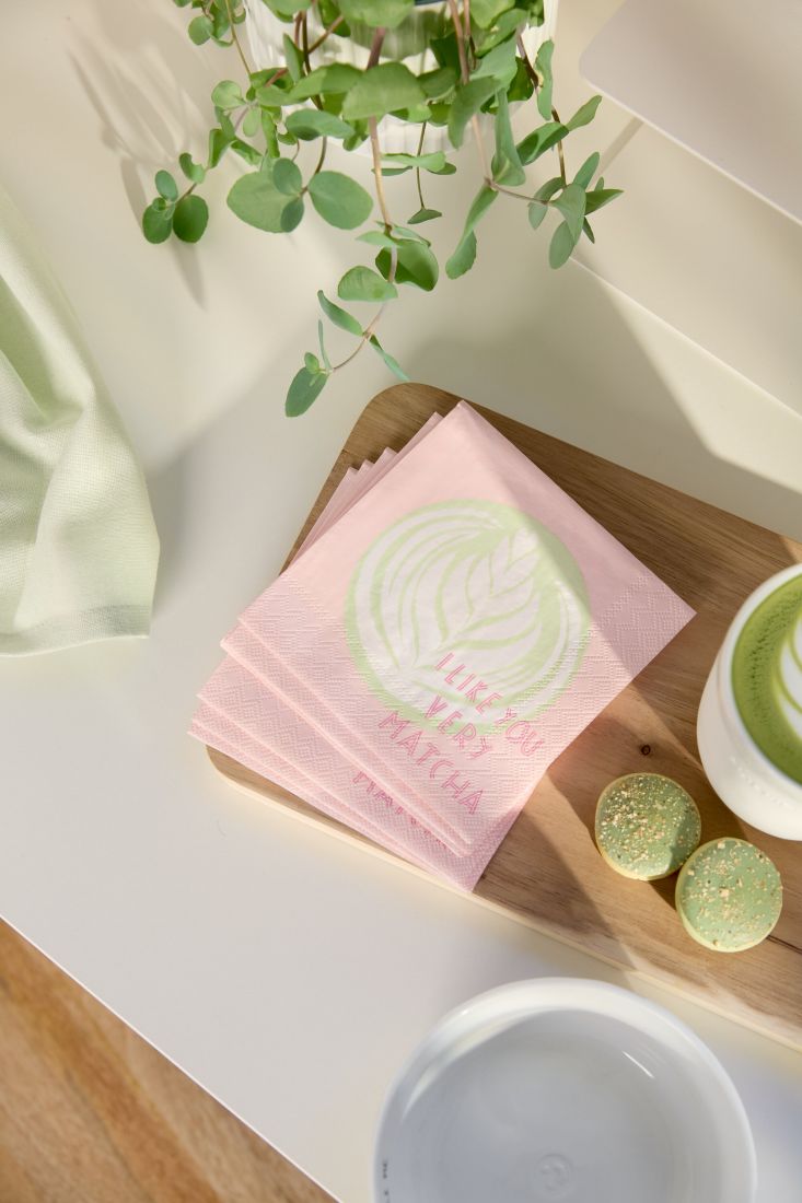 Nahaufnahme der kleinen räder Serviette I like you very Matcha liebevoll dekoriert neben einer Tasse