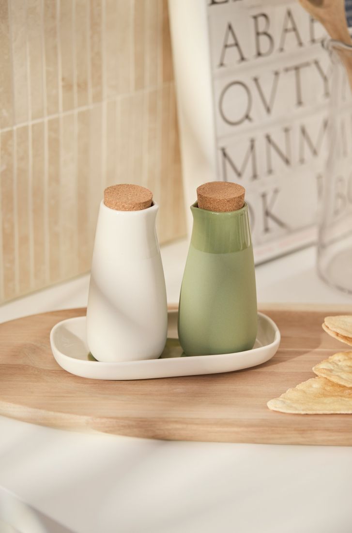 Gedeckter Tisch mit räder Essig- und Öl-Set neben frischem Brot