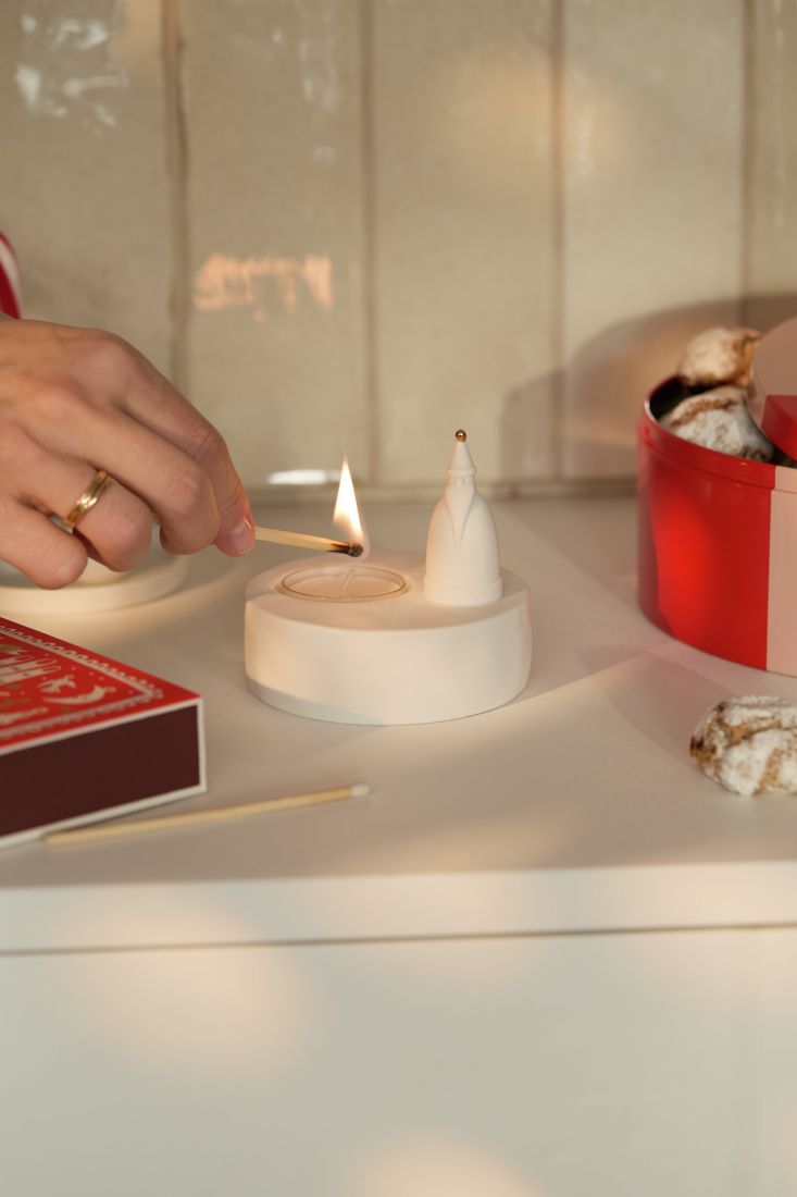 Der leuchtende räder Teelichthalter Weihnachtsmann bei gemütlichem Kerzenschein stilvoll als Weihnachtsdekoration arrangiert