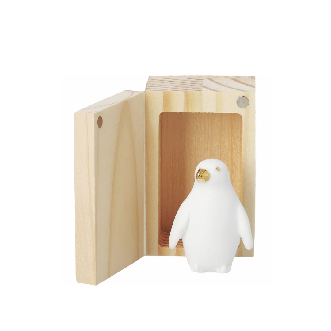 Geöffnetes räder Glückskästchen aus Pinienholz mit kleinem Porzellan-Pinguin und goldenen Details