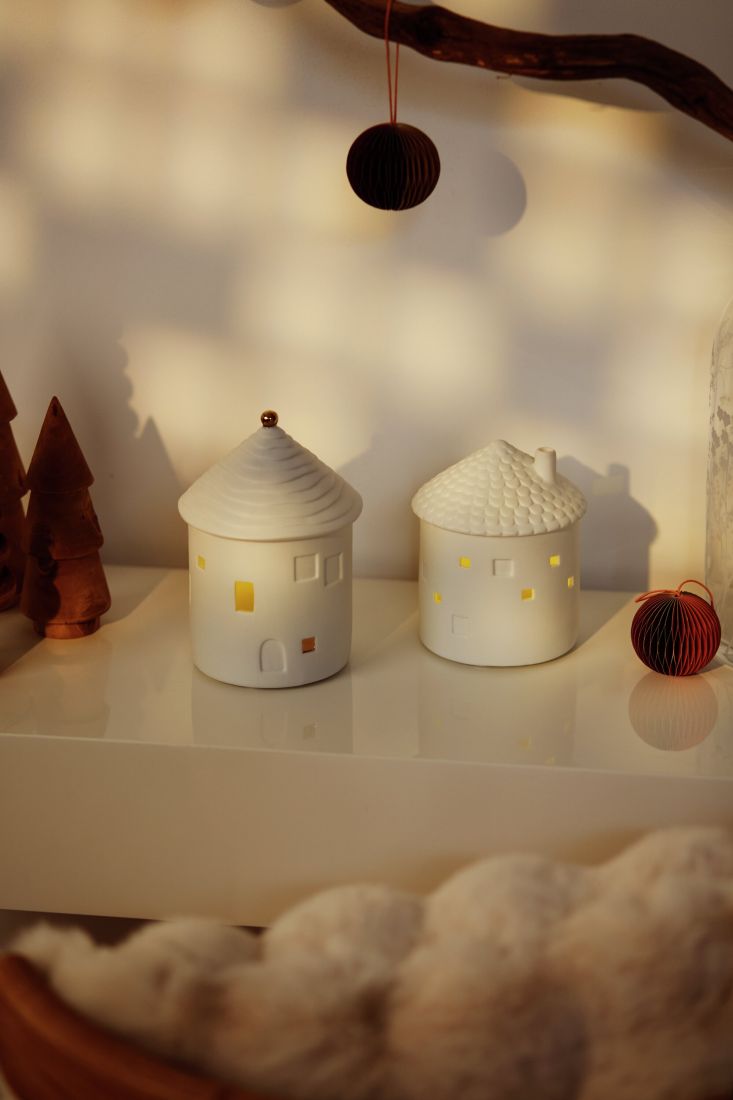 Stimmungsvoll leuchtendes räder Porzellan LED Lichthaus Schornstein integriert in ein Arrangement einer winterlichen Lichterstadt