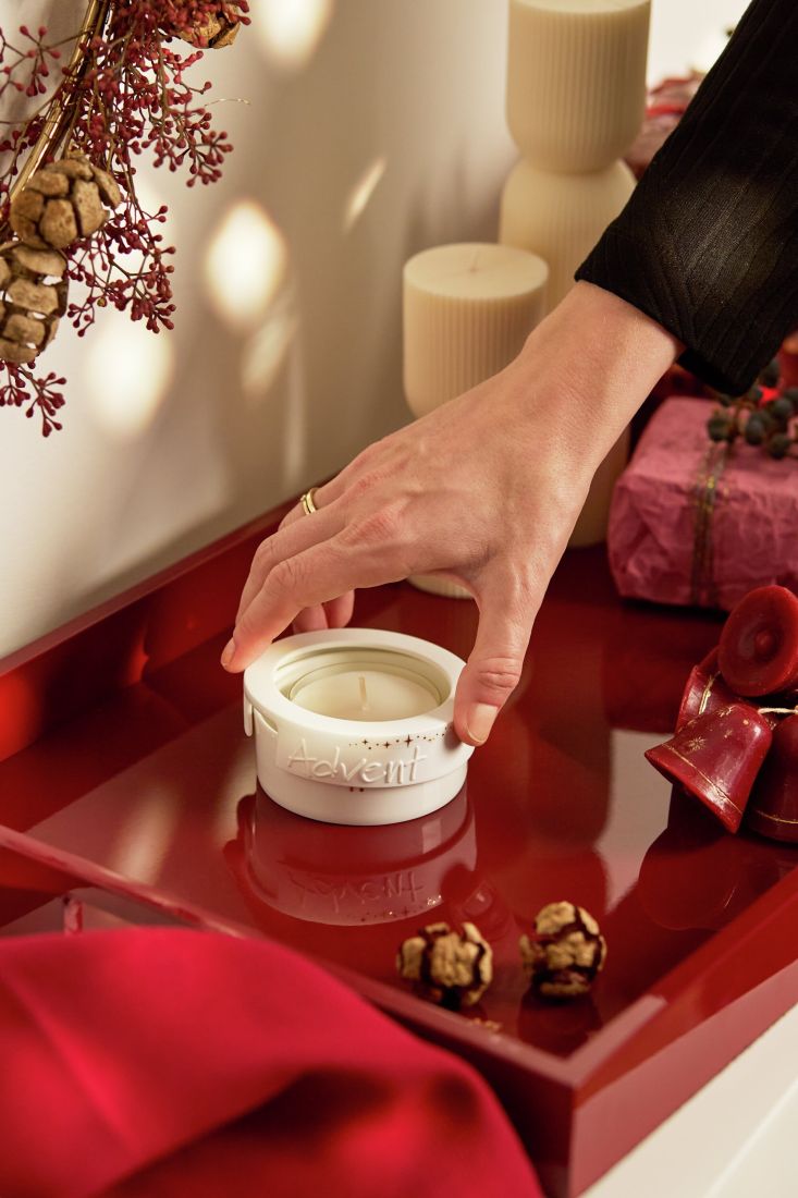 Das leuchtende räder Adventslicht Advent mit glänzenden Gold-Details auf einem festlich gedeckten Tisch