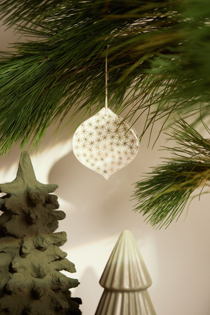 räder Porzellan-Anhänger Goldtropfen dekoriert an einem festlichen Winterzweig