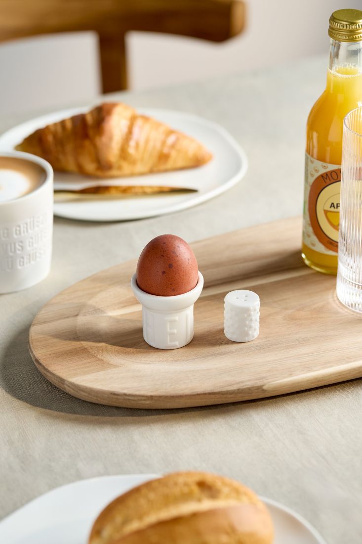 Das dekorative räder Eierbecher Set Heimat stilvoll arrangiert auf einem hölzernen Frühstückstisch