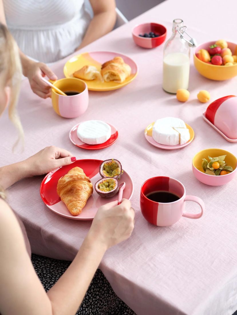 Der zweifarbige Porzellanteller strawberry smoothie von ASA Selection stilvoll auf einem farbenfroh gedeckten Frühstückstisch serviert