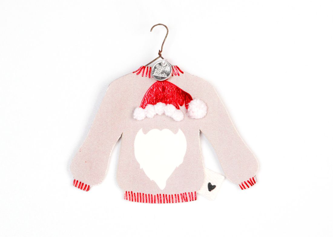 Süßer Anhänger Winterpulli Santa von Good old friends: Papp-Pullover an einem Drahtkleiderbügel mit glänzend roter Mütze, weißen Pompoms und Nikolausbart