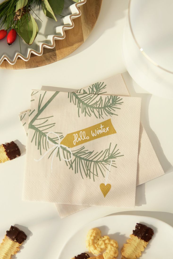 Stilvoll platzierte räder Lunchserviette Hello Winter auf einem winterlich gedeckten Esstisch