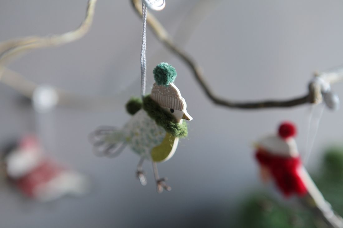 Der Mini Wintervogel Grüner Schal von Good old friends dekorativ an einem Zweig hängend