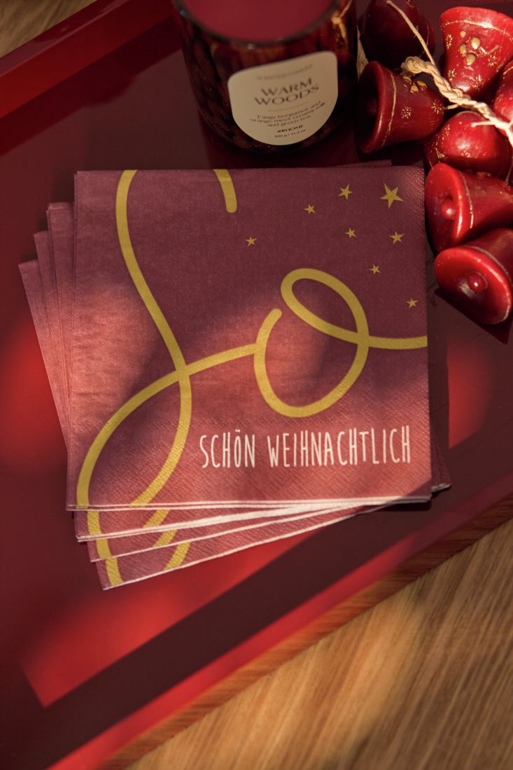 Dekorativ platzierte räder Lunchserviette auf einem weihnachtlich gedeckten Esstisch