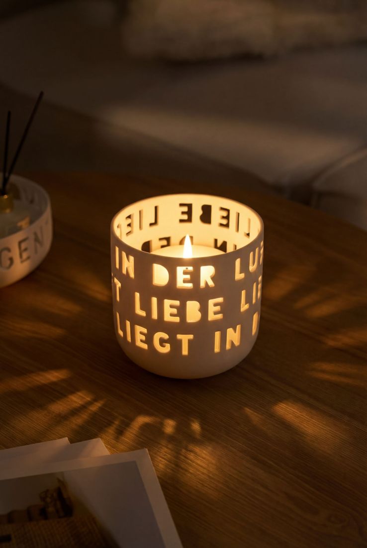 Das beleuchtete räder Porzellan-Windlicht Liebe liegt in der Luft wirft bei gemütlichem Kerzenschein ein romantisches Lichtspiel auf den Tisch