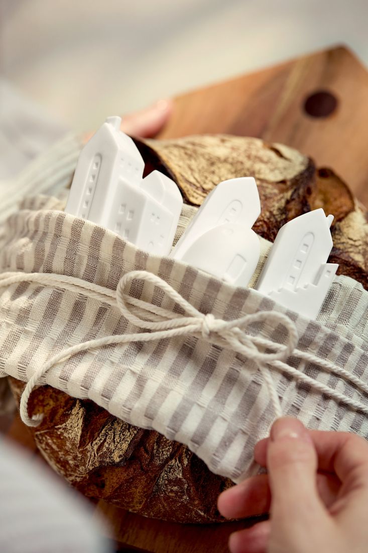 Die räder Stadthäuschen aus Porzellan arrangiert auf einem Brot als Einzugsgeschenk