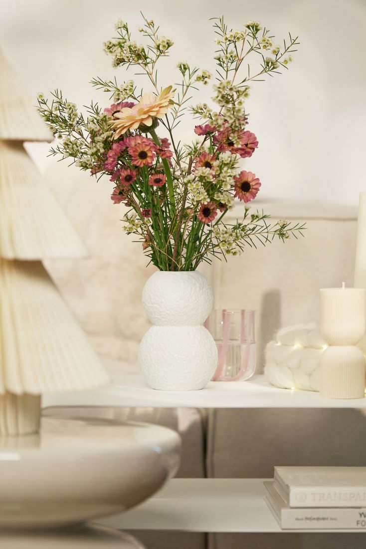 Die elegante räder Vase Schneebälle dekoriert mit mit Blumen auf einem Sidboard