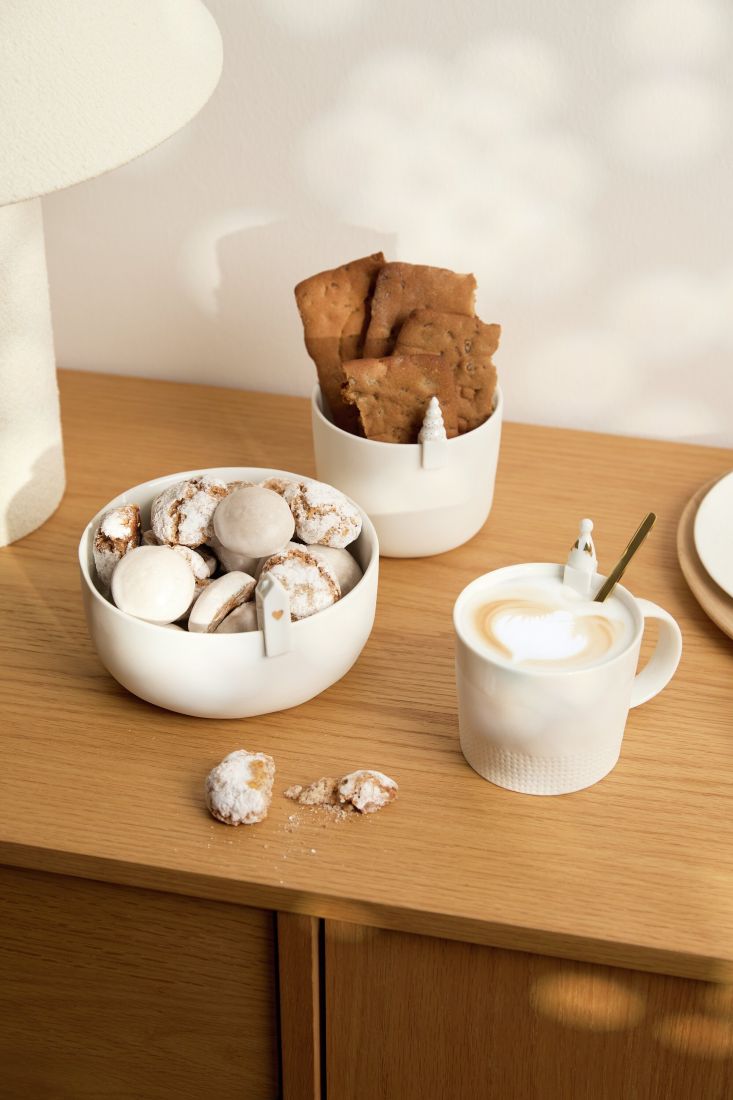 Die räder Kleinen Statisten als süße Randdekor-Elemente an einer Kaffeetasse und einer kleinen Porzellanvase aufgesteckt
