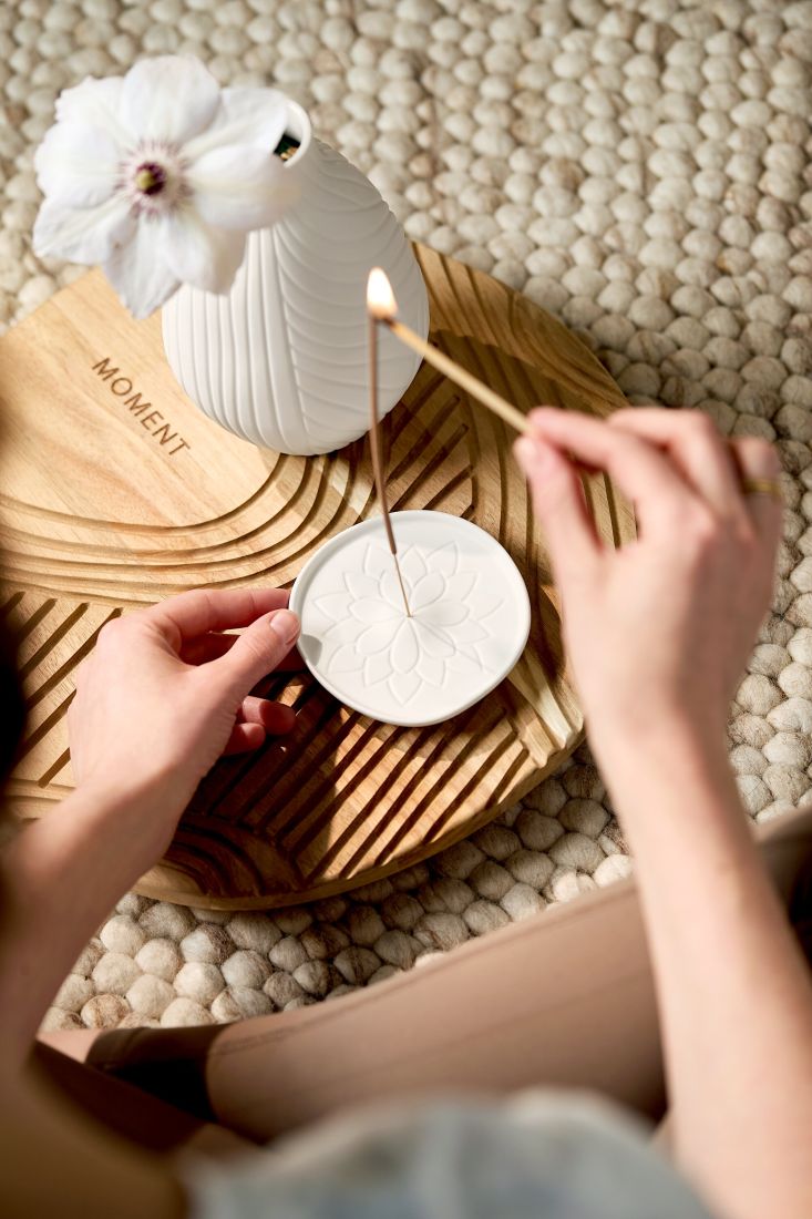 Der edle räder Räucherstäbchenhalter mit einem brennenden Räucherstäbchen in einer ruhigen Yoga- und Meditations-Ecke