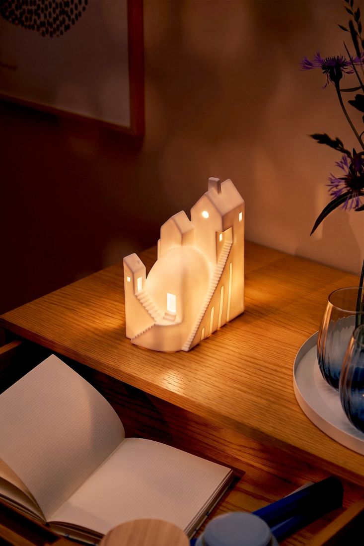 Das räder LED Lichthaus Treppchenstädtchen stimmungsvoll warm leuchtend auf einem Sideboard im Wohnzimmer arrangiert