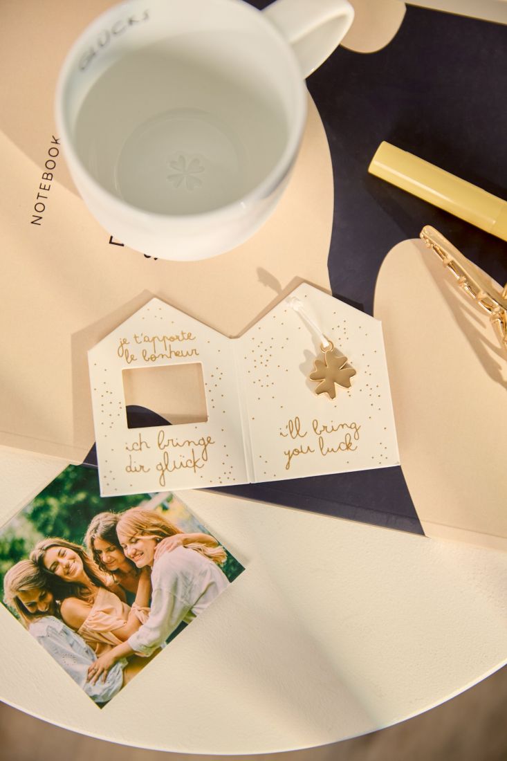 Nahaufnahme des glänzenden kleinen goldenen Kleeblatt-Anhängers von räder Design