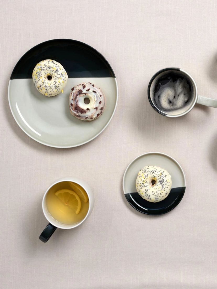 Der zweifarbige Porzellanteller black currant smoothie von ASA Selection stilvoll mit Donuts auf einer modern gedeckten Tafel arrangiert