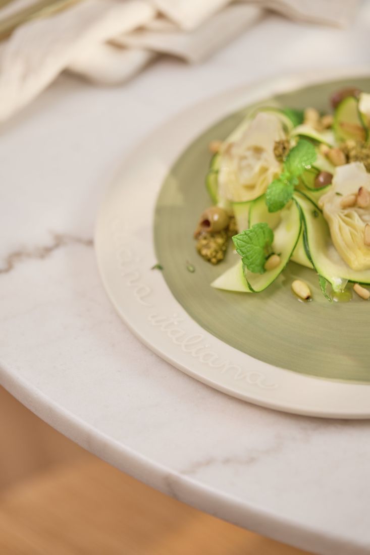 Nahaufnahme des erhabenen Hoch-Relief Schriftzugs cucina italiana  auf dem Tellerrand