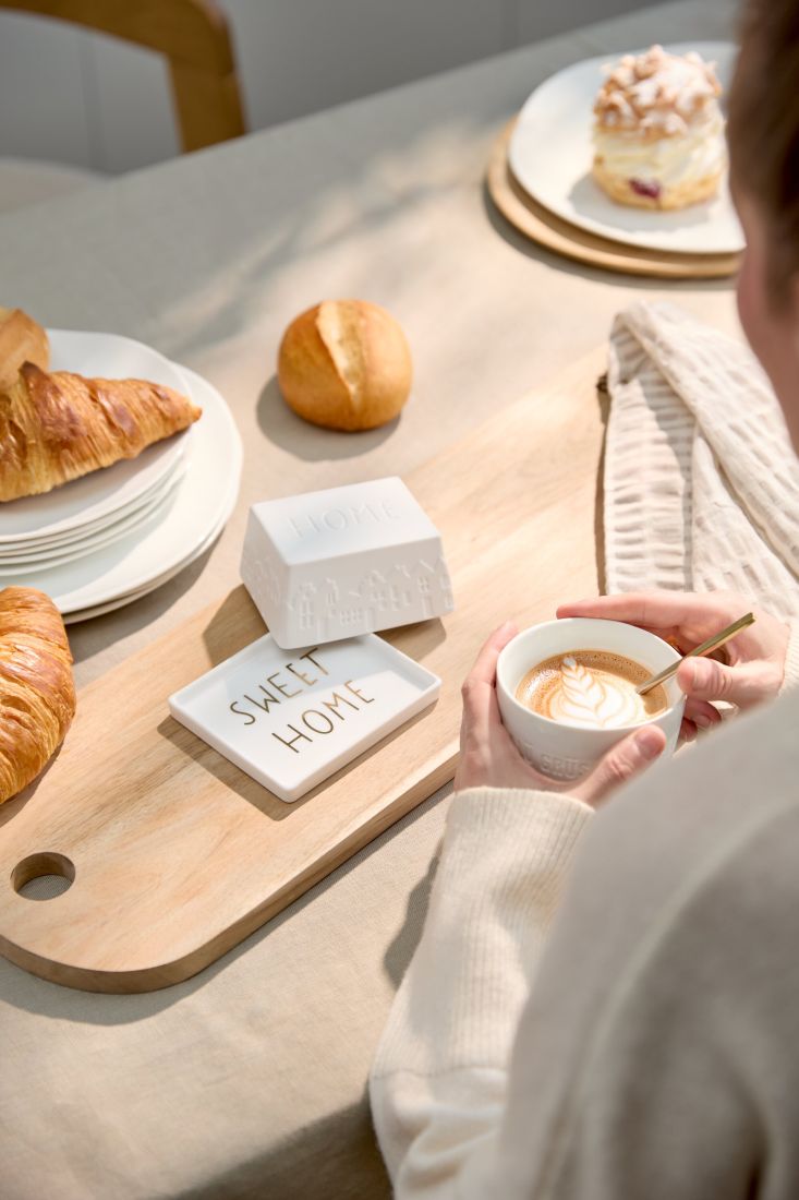 Kleine räder Butterdose für ein viertel Stück Butter stilvoll angerichtet auf einem modernen Frühstückstisch