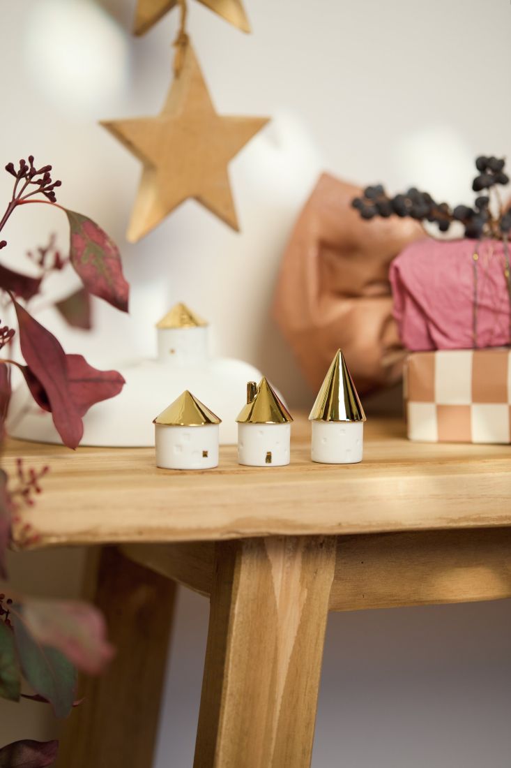 Das räder Minihäuschen 3er Set dekoriert auf einer Holzbank als winterliche Miniaturstadt
