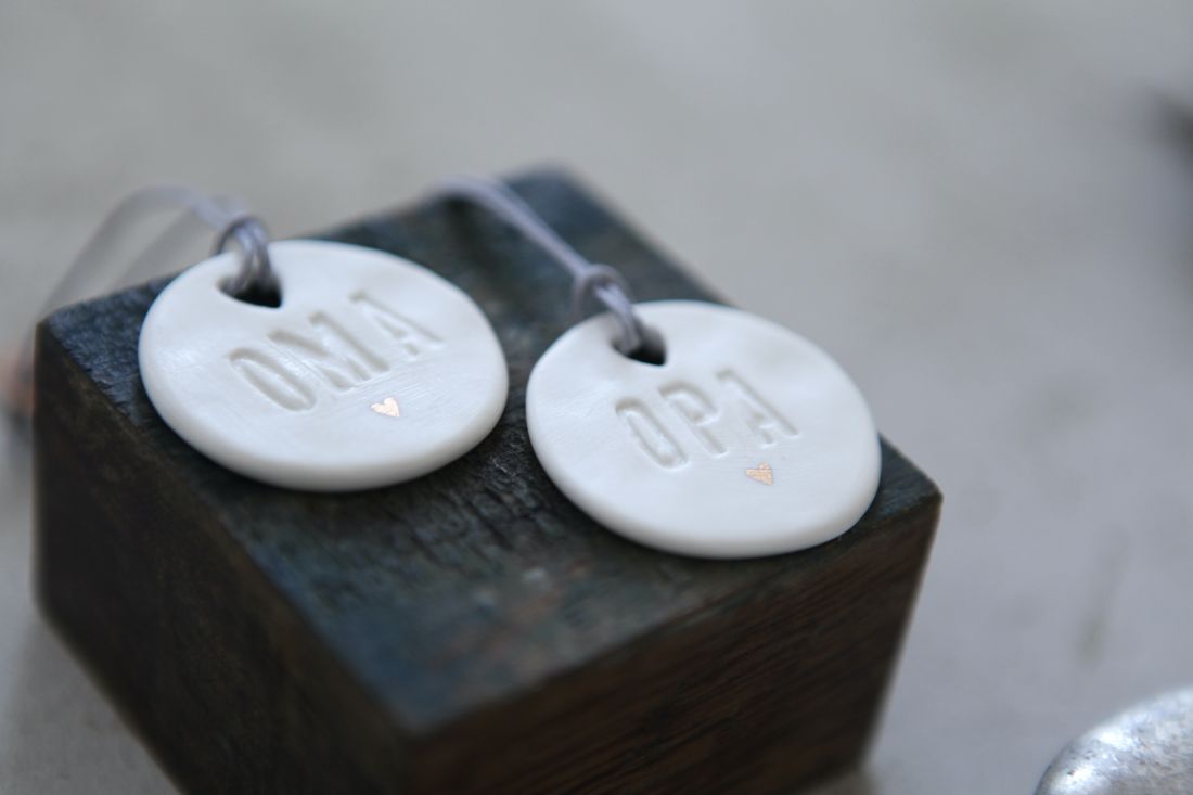 Nahaufnahme der unglasierten Vorderseite des Good old friends Familientalers mit 'Oma'-Relief und goldenem Herz