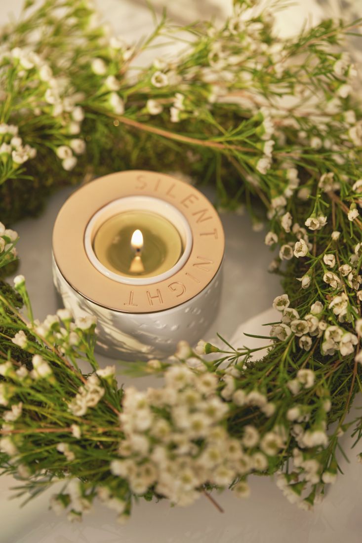 Der leuchtende räder Teelichthalter Silent Night auf einem weihnachtlich gedeckten Tisch bei stimmungsvollem Kerzenschein