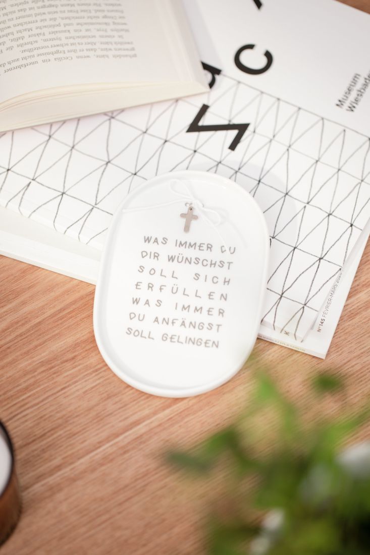 räder Porzellanteller als Geschenkbeilage mit Kreuz und Schleife dekoriert