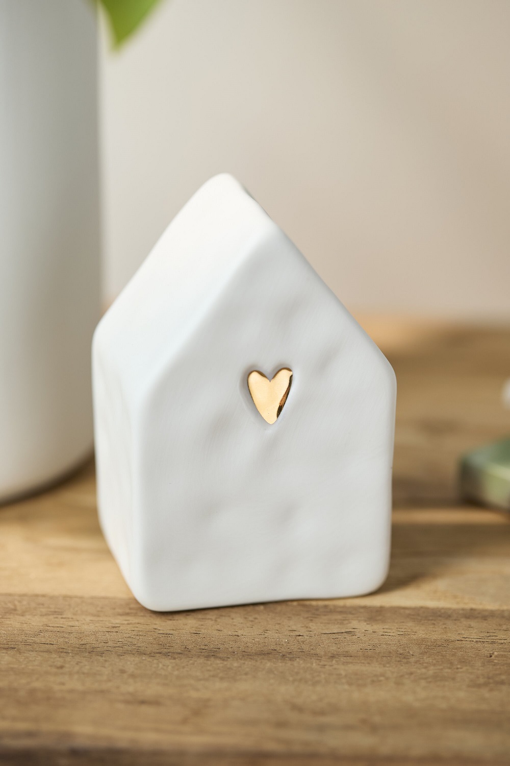 Miniaturhaus, Keramikornament, weißes Haus, Herz-Akzent, Holzoberfläche