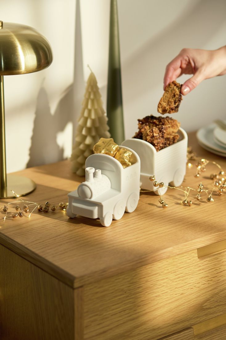 Der dekorative räder Porzellan-Weihnachtszug festlich befüllt mit kleinen Süßigkeiten auf dem Tisch arrangiert