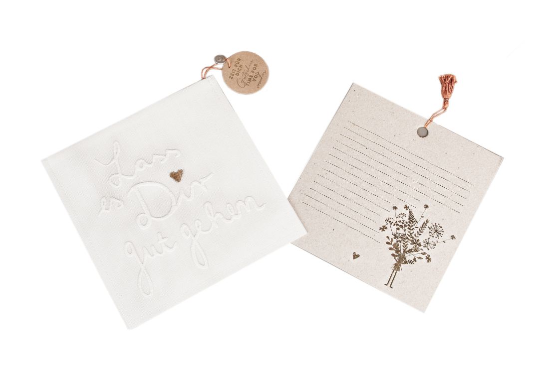 Good old friends Zeitgeschenkgutschein Zeit für Dich bestehend aus weißer Stofftasche mit Schriftzug Lass es Dir gut gehen und Karte mit Blumenstrauß-Motiv