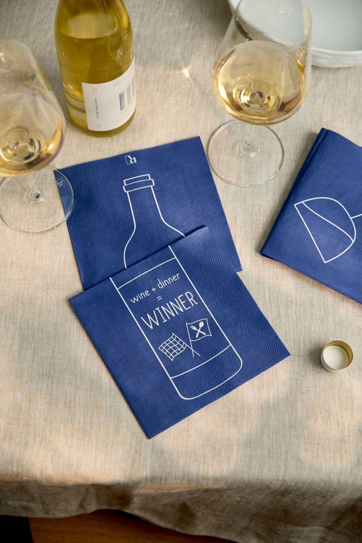Nahaufnahme der räder Serviette Wine + Dinner = Winner stilvoll dekoriert neben einem Weinglas